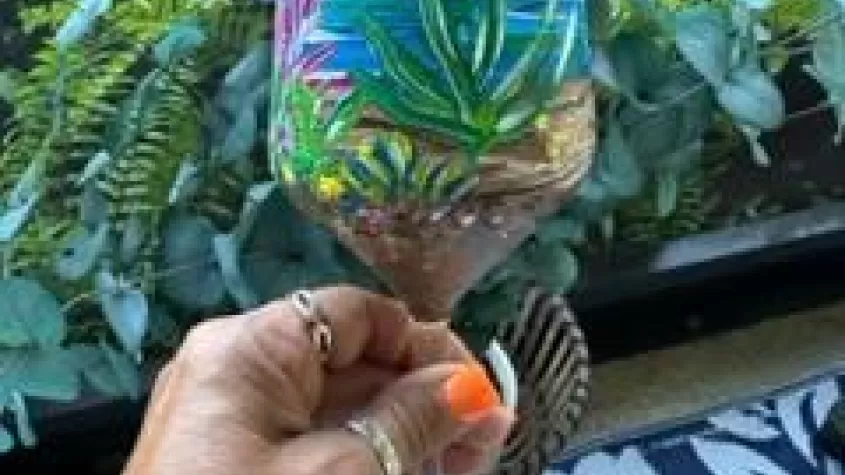 someone holding a painted wine glass with an under water theme